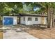 Single-story home featuring a blue garage door, black trim, and fresh landscaping, creating a modern aesthetic at 2014 10Th Nw St, Winter Haven, FL 33881