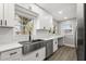 Bright kitchen with white cabinets, stainless steel appliances, and a farmhouse sink, perfect for modern living at 2014 10Th Nw St, Winter Haven, FL 33881