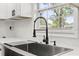 Close-up of a stainless steel sink with modern fixtures and a bright kitchen window at 2014 10Th Nw St, Winter Haven, FL 33881