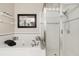 This bathroom showcases a soaking tub next to a shower with white tile and glass doors at 2098 Carpathian Dr, Apopka, FL 32712