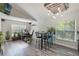 Open-concept living area with workstation, stylish seating, and bar area, featuring wood-look flooring and natural light at 2098 Carpathian Dr, Apopka, FL 32712