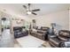 Cozy living room featuring leather seating and plush white area rug on wood flooring at 2098 Carpathian Dr, Apopka, FL 32712