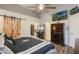 This main bedroom features wood-look flooring, a sliding barn door, and a large television above the chest of drawers at 2098 Carpathian Dr, Apopka, FL 32712