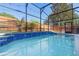 Backyard with screened pool with mature trees in the background at 2098 Carpathian Dr, Apopka, FL 32712