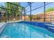 Beautiful blue tiled pool inside screened enclosure with backyard views at 2098 Carpathian Dr, Apopka, FL 32712