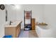 Bright bathroom featuring a soaking tub, vanity, and storage shelving at 2658 Palmetto Ridge Cir, Apopka, FL 32712