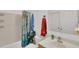 Bathroom featuring a shower-tub combo with a patterned curtain, a white toilet, and storage shelves at 2658 Palmetto Ridge Cir, Apopka, FL 32712