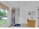 Bright bathroom with a shower, vanity, and large window overlooking a green yard at 2658 Palmetto Ridge Cir, Apopka, FL 32712