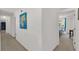 Hallway featuring artwork and a view into a bedroom with natural light at 2658 Palmetto Ridge Cir, Apopka, FL 32712