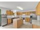 Spacious kitchen with stainless steel appliances, island, and light wood cabinets at 2658 Palmetto Ridge Cir, Apopka, FL 32712