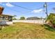 Large backyard with a covered patio, grass, white fence, and lush landscaping at 2665 E Juliet Dr, Deltona, FL 32738