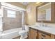 Bathroom featuring vanity with a wooden cabinet, toilet, mirror, shower, and tiled walls at 2665 E Juliet Dr, Deltona, FL 32738