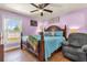 Cozy bedroom features a queen-sized bed, warm lighting, and a comfortable reading chair at 2665 E Juliet Dr, Deltona, FL 32738