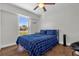 Bedroom with blue bed set, wooden floors, bright window with natural light and ceiling fan at 2665 E Juliet Dr, Deltona, FL 32738