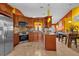 Open-concept kitchen with dark wood cabinets, stainless appliances, tile backsplash, and bar seating at 2665 E Juliet Dr, Deltona, FL 32738