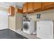 Laundry room featuring a washer, dryer, storage cabinets, and a painted concrete floor at 2665 E Juliet Dr, Deltona, FL 32738