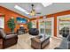 Open living room featuring skylights, ceiling fan, tile floors, and a cozy entertainment center at 2665 E Juliet Dr, Deltona, FL 32738