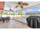 Enclosed patio with ceiling fans, table, chairs, and grill overlooking fenced yard at 2665 E Juliet Dr, Deltona, FL 32738