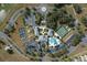 Aerial view of community clubhouse featuring a pool, tennis courts, and ample parking at 27127 Stoney Brook Dr, Leesburg, FL 34748