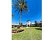 Beautiful clubhouse with a clock tower surrounded by palm trees and vibrant landscaping at 27127 Stoney Brook Dr, Leesburg, FL 34748