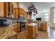 Well-lit kitchen featuring wooden cabinetry, stainless steel appliances, and a central island at 27127 Stoney Brook Dr, Leesburg, FL 34748