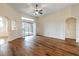 Spacious living room with hardwood floors, archways, and patio doors with plantation shutters at 27127 Stoney Brook Dr, Leesburg, FL 34748