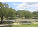 Street view showcasing lush green trees and landscaping under a partly cloudy blue sky at 280 Celebration Blvd # 208, Kissimmee, FL 34747