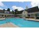 Stunning community pool with inviting blue water surrounded by beautiful clubhouse and lounge area at 280 Celebration Blvd # 208, Kissimmee, FL 34747