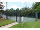 Community tennis court with secure fencing, surrounded by trees and a clear walkway at 280 Celebration Blvd # 208, Kissimmee, FL 34747