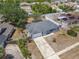 Aerial view of a gray roof home with an attached garage, surrounded by a fenced yard and greenery at 2818 Irondale St, Deltona, FL 32738