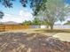 A spacious backyard features a concrete patio, a mature shade tree, and a wooden fence at 2818 Irondale St, Deltona, FL 32738