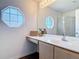 Bathroom vanity with large mirror, stylish decor, and unique octagonal window at 2818 Irondale St, Deltona, FL 32738