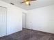 A carpeted bedroom is illuminated by a ceiling fan and features a closet and a door at 2818 Irondale St, Deltona, FL 32738