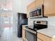 Well-lit kitchen boasts stainless steel appliances and an easy-to-clean tile floor at 2818 Irondale St, Deltona, FL 32738