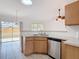 Bright kitchen features wood cabinets, stainless steel dishwasher, and a double-basin sink at 2818 Irondale St, Deltona, FL 32738