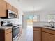 Galley kitchen features stainless steel appliances, wood cabinets, and access to the backyard at 2818 Irondale St, Deltona, FL 32738