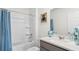 Clean bathroom with a shower-tub combo, gray vanity, and neutral tile for a fresh, modern feel at 3018 Salisbury Ave, Haines City, FL 33844