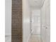 Hallway featuring brick accent wall, tiled floor entry, with doorways to bedroom and closet at 3204 Amherst Ave, Orlando, FL 32804