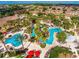 Aerial view of a resort featuring multiple pools, lush landscaping, and residential buildings at 416 Calabria Ave, Davenport, FL 33897