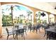 Charming outdoor dining area with tables, chairs, and lush tropical landscaping at 416 Calabria Ave, Davenport, FL 33897
