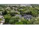 This aerial view showcases a neighborhood filled with lush trees, homes, and a nearby building at 4411 Little Water St, Orlando, FL 32817