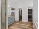 Bright open bathroom with wood flooring, a walk-in shower, and double doors to a large walk-in closet at 4411 Little Water St, Orlando, FL 32817