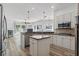 Modern kitchen with an island, stone countertops, and stainless steel appliances adjoining a living area at 4411 Little Water St, Orlando, FL 32817