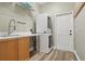 Laundry room with washer/dryer hookups, sink, storage shelves, and wood look flooring at 4411 Little Water St, Orlando, FL 32817