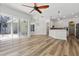 Bright open-concept living area features wood floors, ceiling fan, and sliding glass doors to the outdoor space at 4411 Little Water St, Orlando, FL 32817