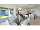 Dining area adjacent to the kitchen featuring a glass table, modern chairs, and sliding glass doors at 4582 Boxwood Way, Mount Dora, FL 32757