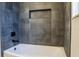 Modern bathroom features a white tub with sleek gray tile backsplash at 4837 Lorraine Way, Orlando, FL 32812