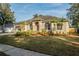 Well-manicured lawn leads to a single-story home with arched windows and a neutral color palette at 4837 Lorraine Way, Orlando, FL 32812