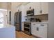 Modern kitchen featuring white cabinets, stainless steel appliances, and quartz countertops with backsplash at 4837 Lorraine Way, Orlando, FL 32812