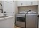 Functional laundry room features a sink, storage cabinets, and side-by-side washer/dryer at 4837 Lorraine Way, Orlando, FL 32812